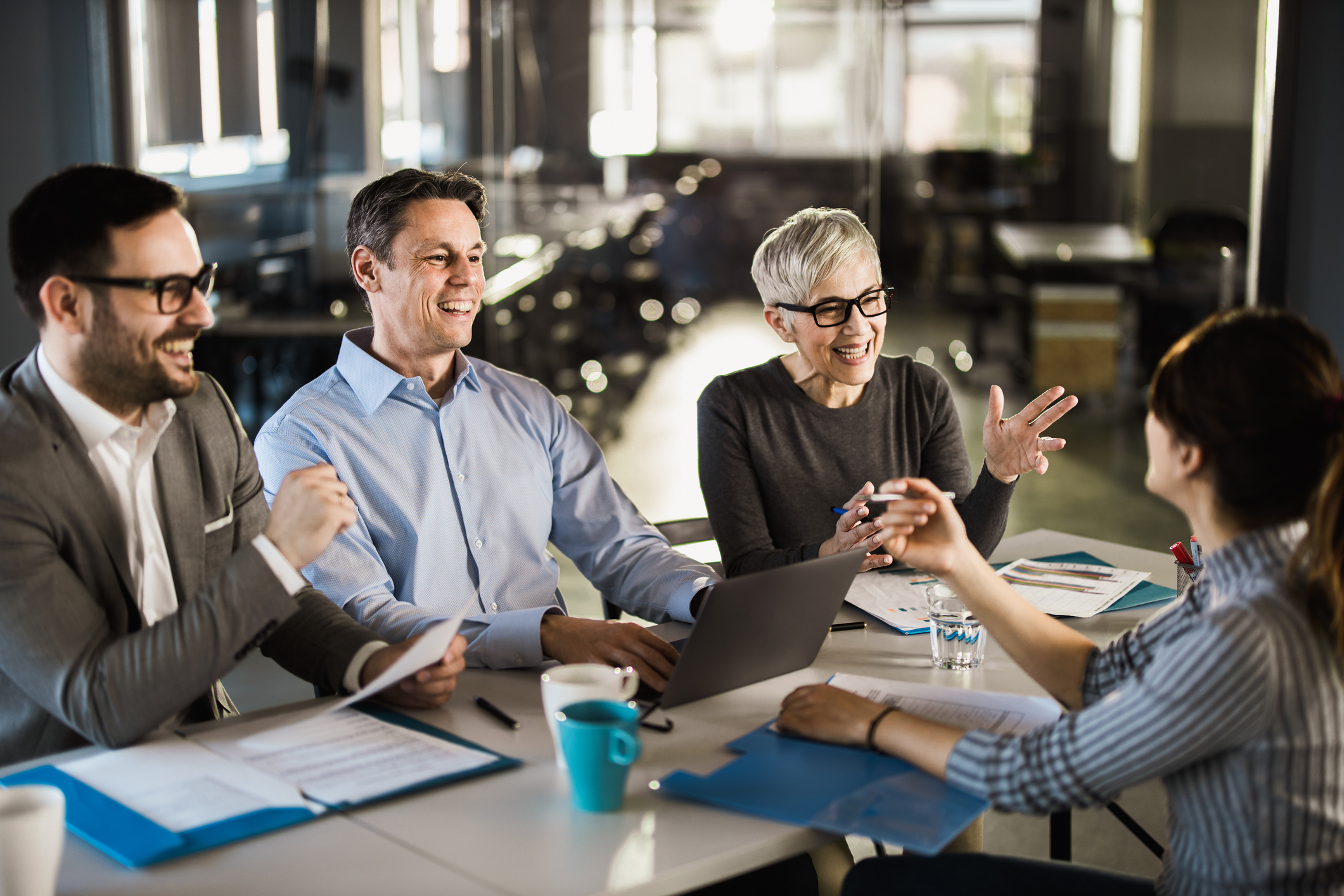 A staffing team talking with a human resources candidate in a meeting room.